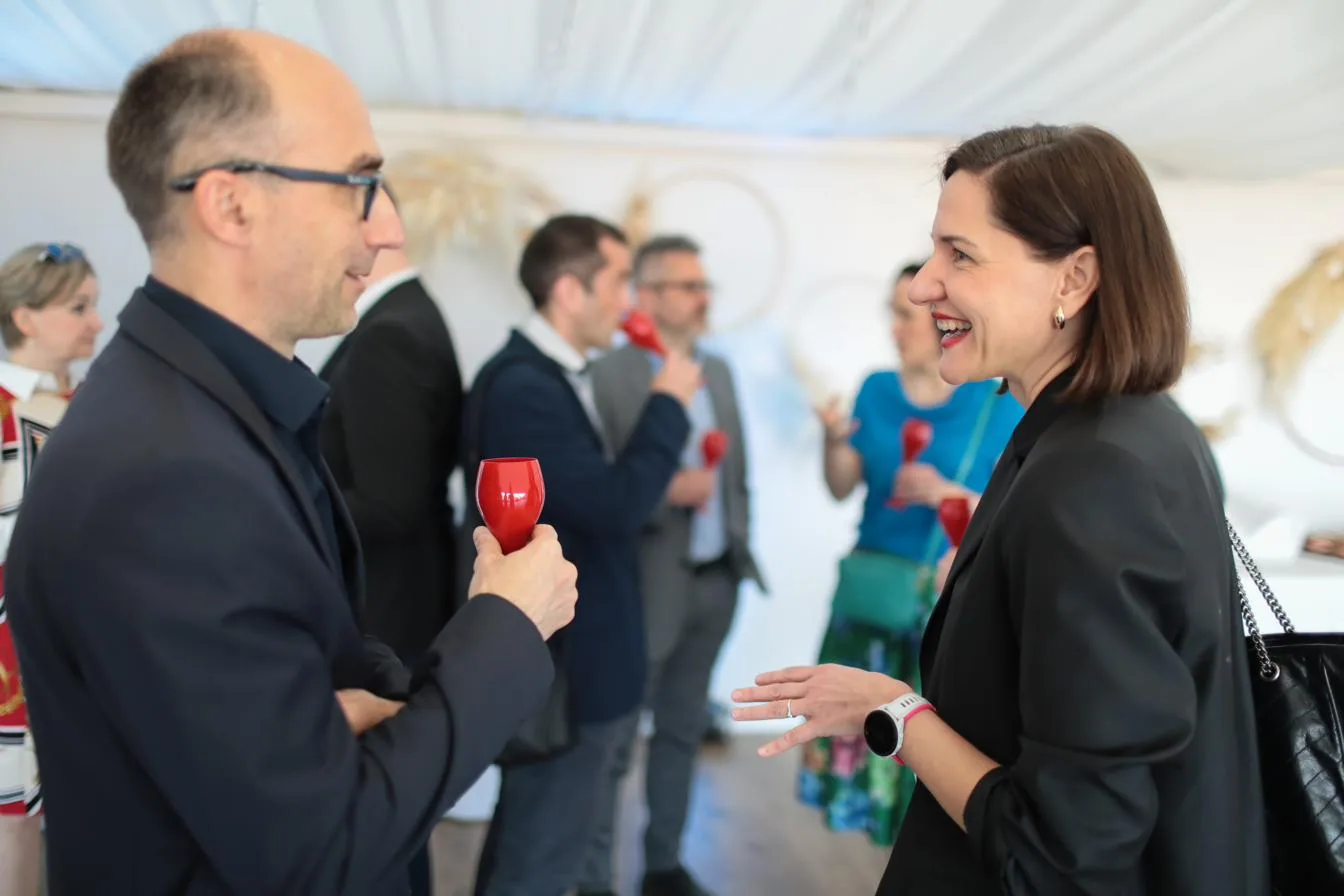 Živý rozhovor hostí recepcie s výhľadom na mesto